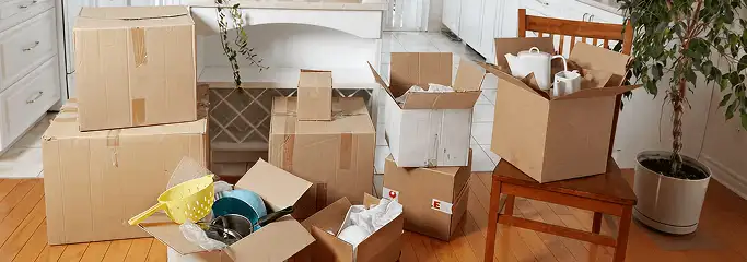Packed moving boxes and household items in a kitchen before move-out or move-in cleaning, Pueblo, CO.